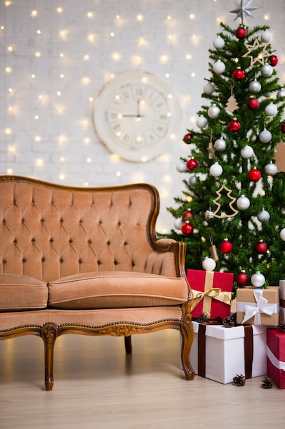 Christmas background - interior with christmas tree, vintage sofa and gift boxes