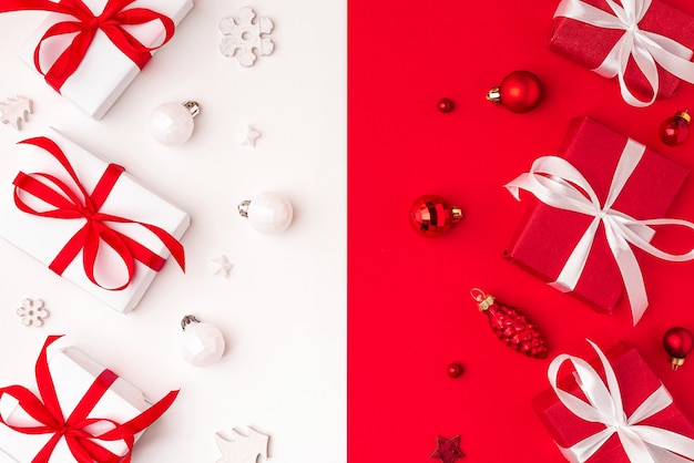 Christmas background. Red and white gift boxes with Christmas decorations on red and white background. Top view. Flat lay