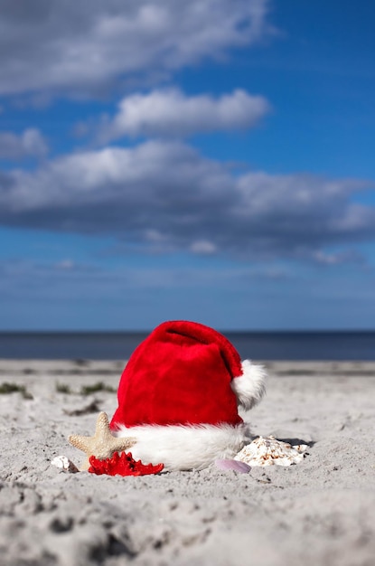 Christmas background Santa Claus hat on the beach