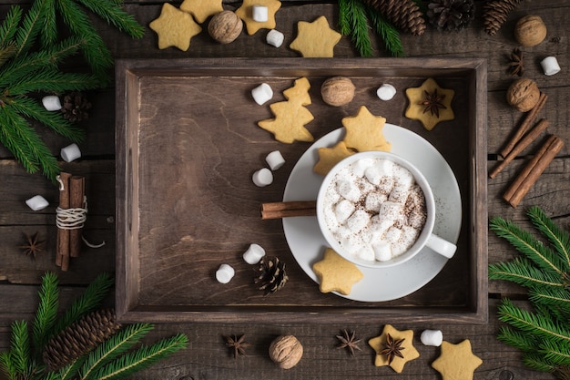 Christmas background. Tray with cocoa and cookies, decorated with cinnamon and marshmallow.