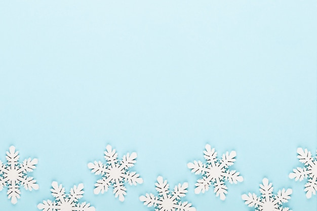 Christmas background. White snow decorations on a pink background.