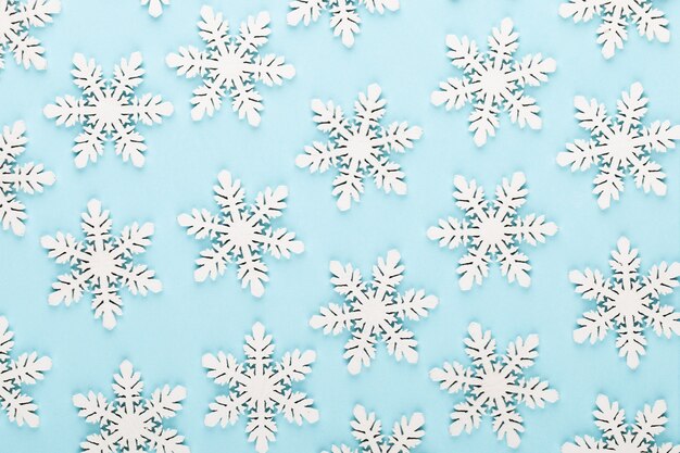 Christmas background. White snow decorations on a pink background.