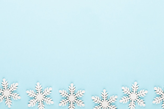 Christmas background. White snow decorations on a pink background.