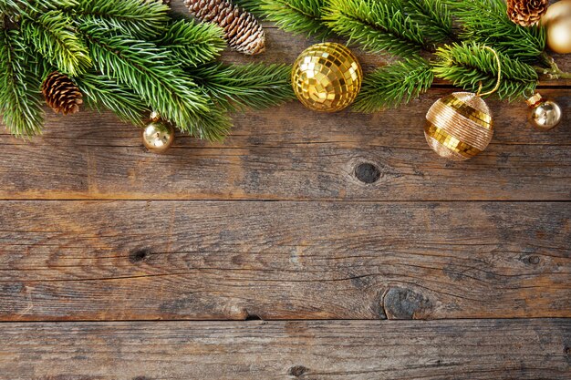 Christmas background with baubles, fir and present on old wooden table.