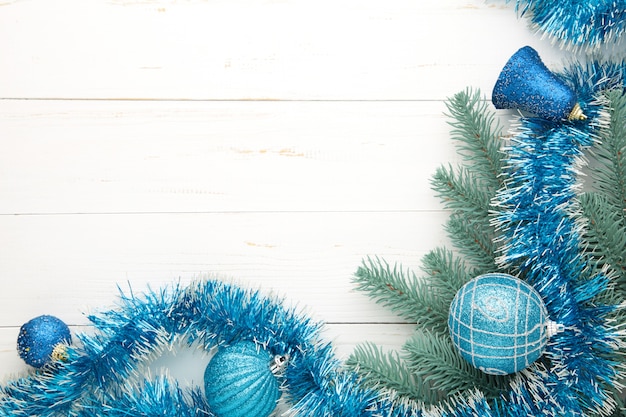 Christmas background with blue decorations on white wooden background. Top view.