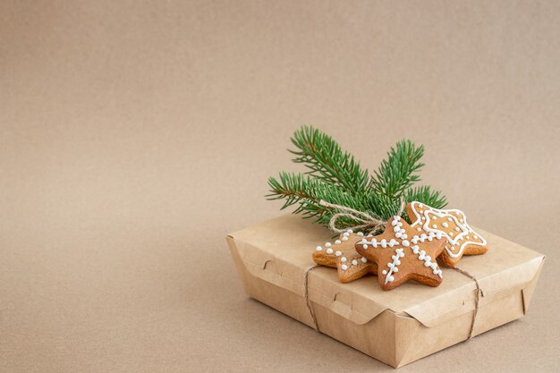 Sfondo di natale con una scatola di biscotti di pan di zenzero e un ramo di un albero di natale