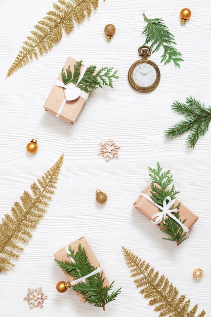 Photo christmas background with bright golden toys craft gift with natural green thuja branches