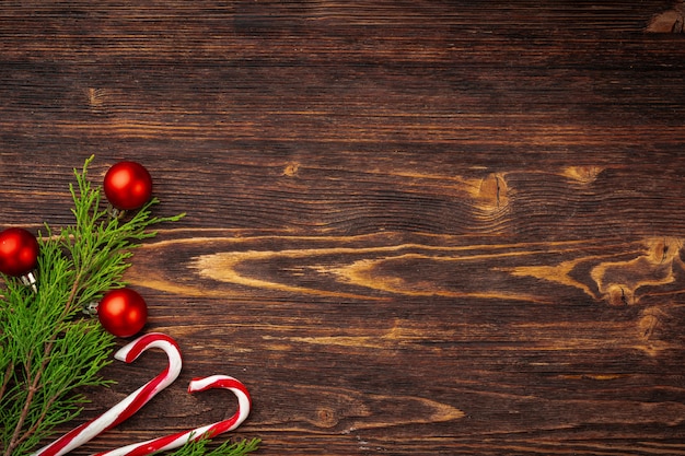 Christmas background with candy cane on decorated wooden desk 