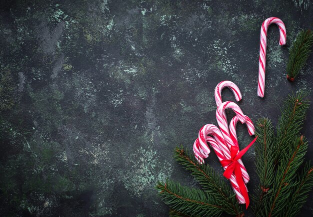 Sfondo di natale con bastoncini di zucchero e rami di abete