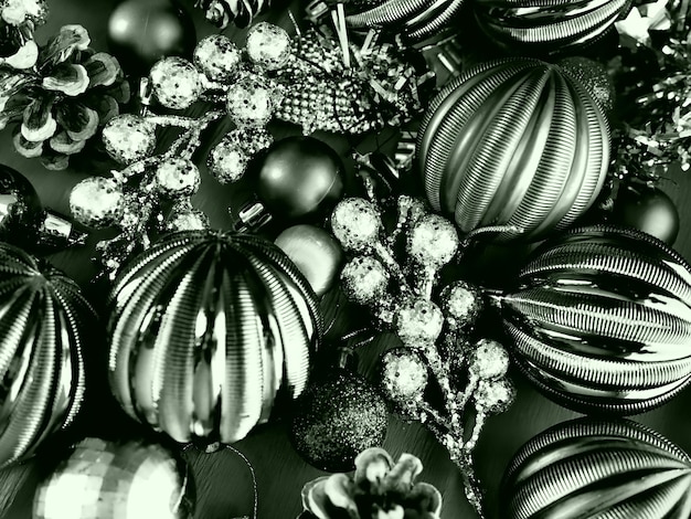 Christmas background with Christmas decorations holiday balls bells bows fir cone Christmas tinsel Happy New Year and Merry Christmas Black and white monochrome photo with green filter