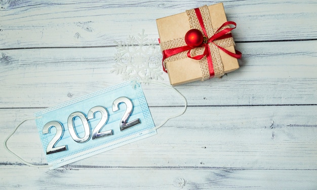 christmas background with christmas gift box medical mask with numbers 2022