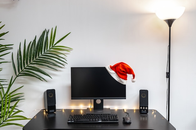 Christmas background with computer setup with a hat and copy space for text