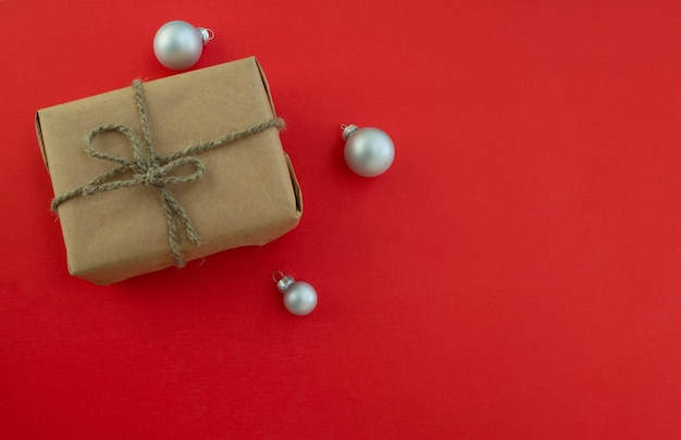 복사 공간이 있는 크리스마스 배경 빨간색 배경에 공예 종이와 크리스마스 공으로 만든 선물