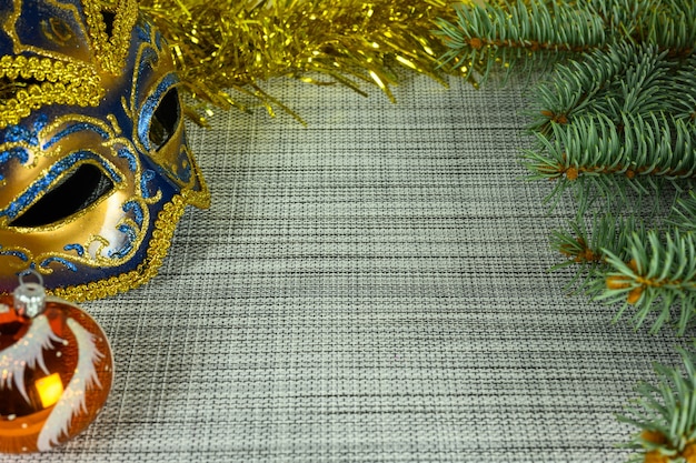 Christmas background with copy space, mask, ball and fir branches. Christmas and New Year concept.