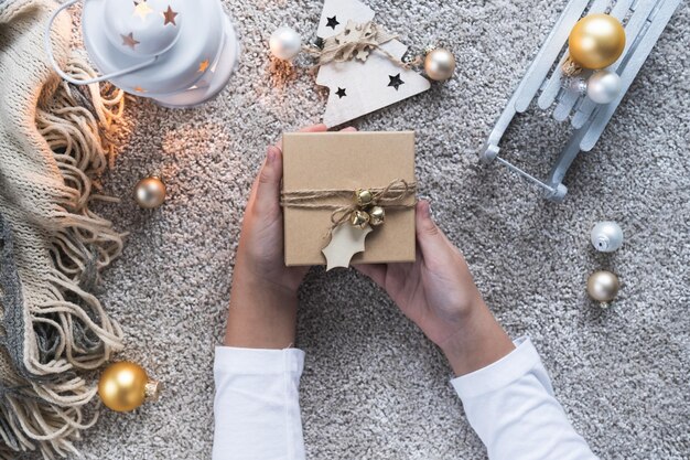 Christmas background with cozy winter atmosphere Children's hands holding new year's gift