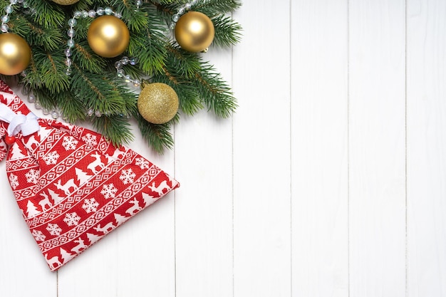 Christmas background with decorated fir tree and red gift bag Top view flat lay with copy space