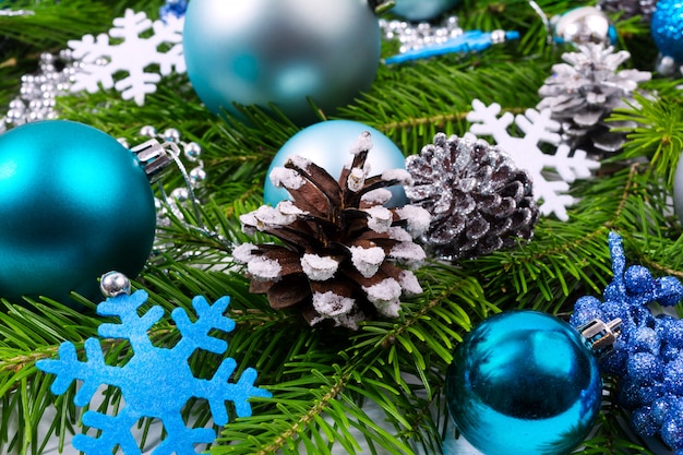 Christmas background with decorated pine cones, turquoise balls and blue snowflake