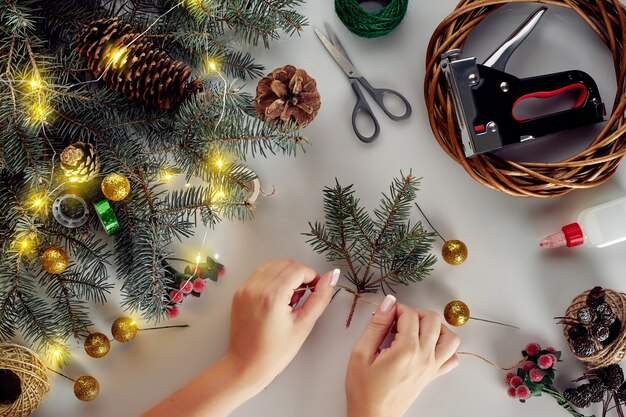 Christmas background with decorations, garland and pine cones. Creating wreath made of christmas tree branches on white background.