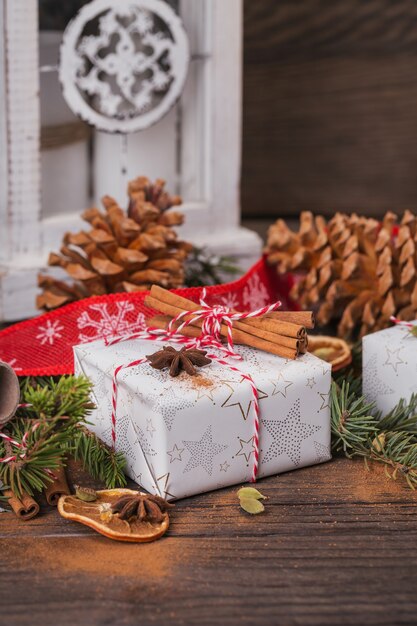 Sfondo di natale con decorazioni e scatole regalo su tavola di legno scuro.