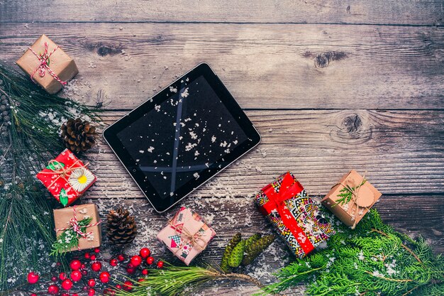 Christmas background with decorations and gift boxes on wooden board.