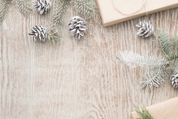 Sfondo di natale con decorazioni e confezioni regalo su un tavolo di legno. disposizione piana, vista dall'alto. composizione di natale