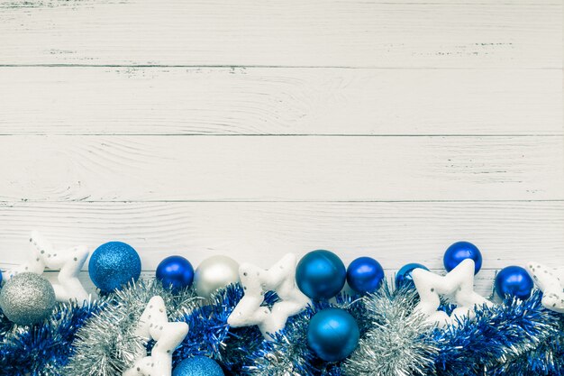 Christmas background with decorative composition of blue and silver Christmas balls, white stars and tinsel. Happy new year. Copyspace