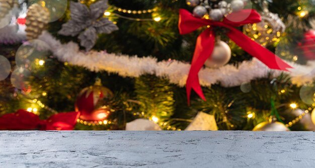 Christmas background with an empty tabletop on the background of a decorated christmas tree. unfocused. side view, copy space