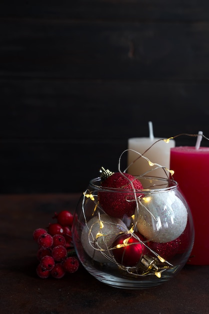 Christmas background with festive decoration, candles, light and balls in jar. 