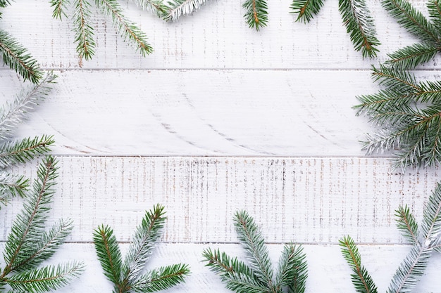 Christmas background with fir branches,  on the old white wooden board. Top view.