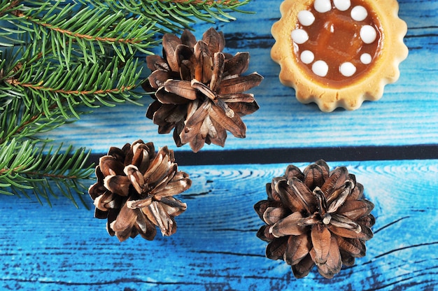 Christmas background  with fir cones, tree branches and cake 