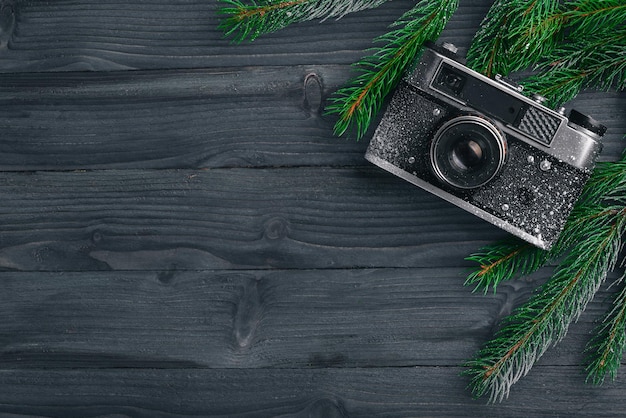 나무 배경 위에 전나무 선물과 카메라가 있는 크리스마스 배경 상위 뷰 텍스트를 위한 여유 공간