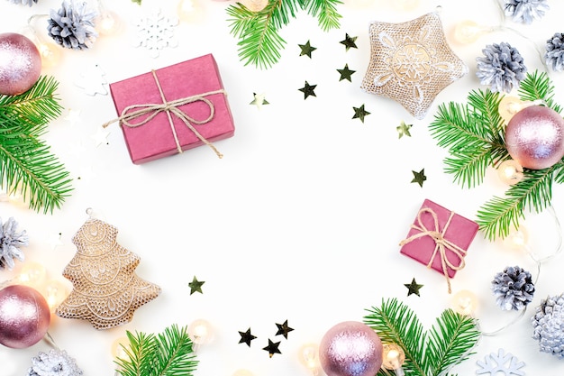 Christmas background with fir tree branches, Christmas lights, presents, pink and beige decorations, silver ornaments