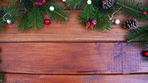 Christmas background with fir tree and decoration on wooden board