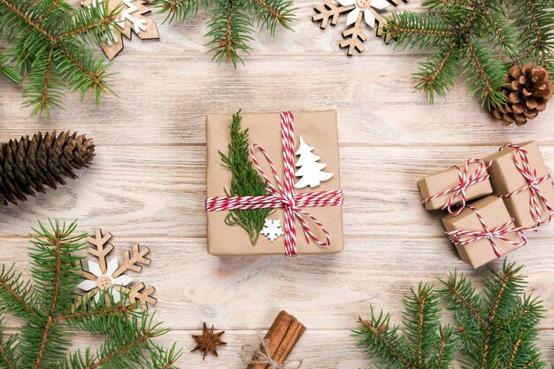 Christmas background with fir tree and gift box on wooden table.