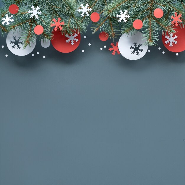 Christmas background with fir twigs, red and white paper decorations, copy-space