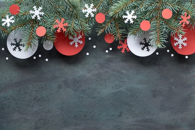 Christmas background with fir twigs, red and white paper decorations