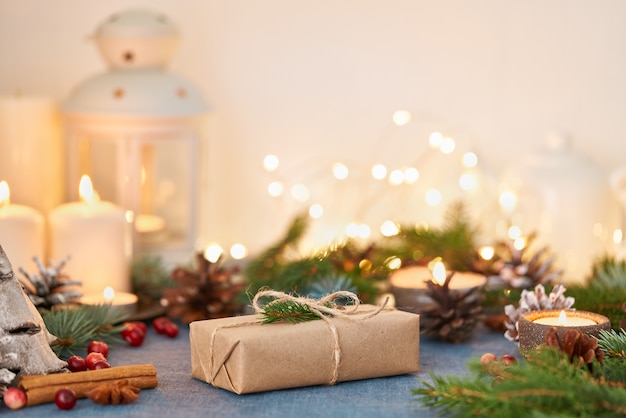 Sfondo di natale con confezione regalo e decorazioni, candele e ghirlande di luci. felice anno nuovo