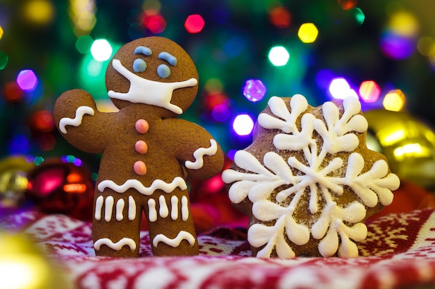 Christmas background with gingerbread man with protective medical mask