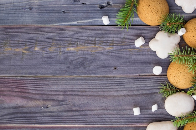 Christmas background with gingerbread, marshmallow and branch of fir tree