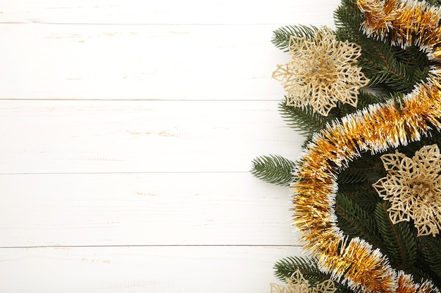 Christmas background with gold decorations on white wooden background. Top view.