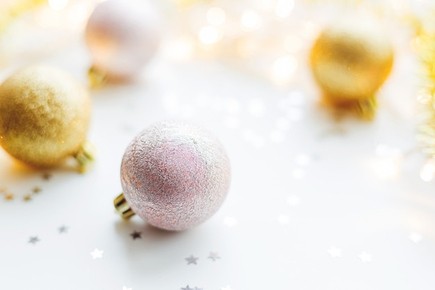 Christmas background with golden decorative balls for Christmas tree with light bulbs and confetti. 