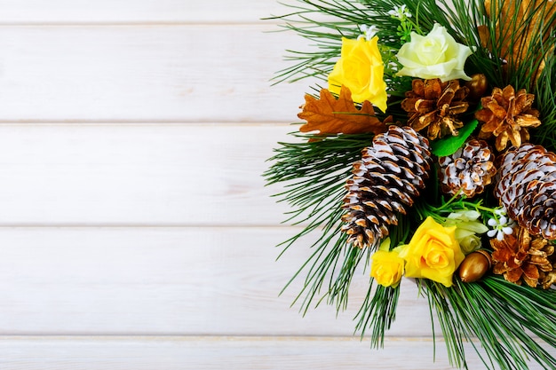 Christmas background with golden pine cones and yellow fabric roses
