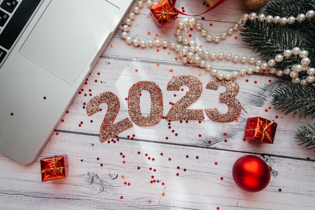 Christmas background with New Year's toys, decorations and laptop on a wooden background.