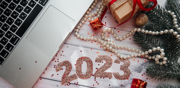 Christmas background with New Year's toys, decorations and laptop on a wooden background.