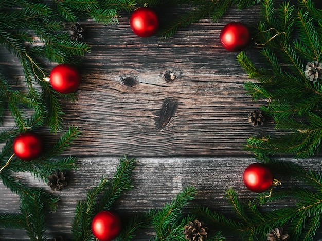 Фото Рождественский фон с красными шарами, еловыми ветками и шишками