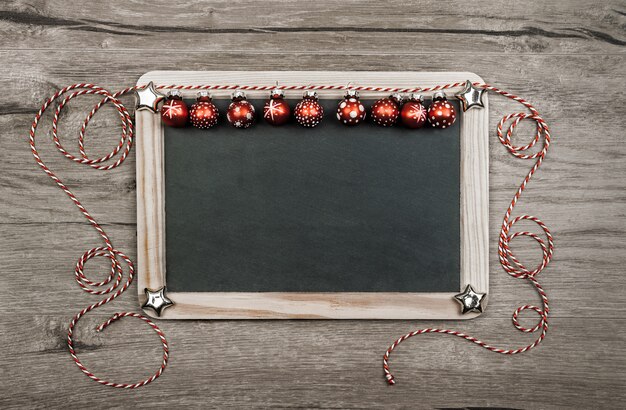 Christmas background with red trinkets, text space on blackboard