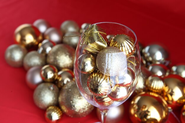 Photo christmas background with vine glass and gold christmas decorations inside it. vine glass with christmas decorations