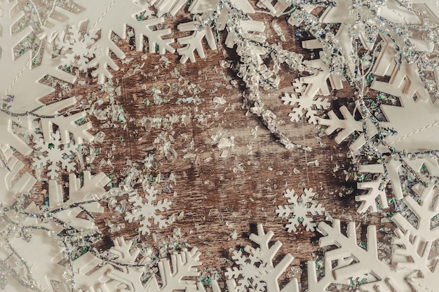 Christmas background with white snowflakes on wooden table.