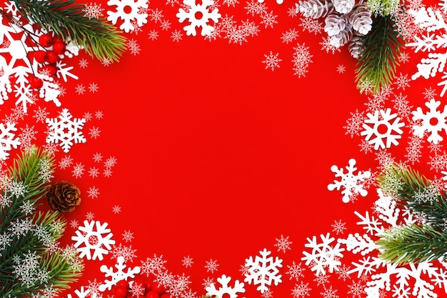 Christmas background with xmas tree branches and snowflakes on red canvas background. Merry christmas card. Happy New Year.