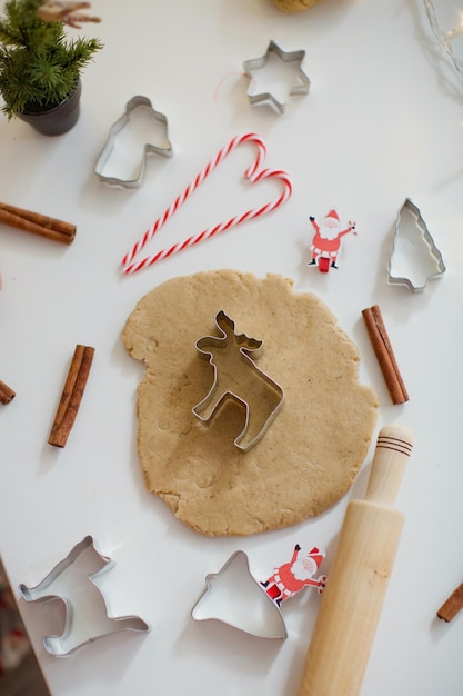 크리스마스 베이킹 배경 반죽 쿠키 커터 향신료와 크리스마스 장식 흰색 테이블에 크리스마스 쿠키